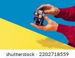 Small photo of Pop art photography. Colorful image of retro photo camera on bright yellow tablecloth isolated over blue background. Concept of art culture, vintage things, mix old and modernity. Copy space for ad