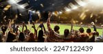 Small photo of Back view of football, soccer fans cheering their team, holding flag at crowded stadium at evening time. Concept of sport, cup, world, team, event, competition, hobby, lifestyle, emotions