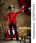 Small photo of Showman. Vintage portrait of male retro circus entertainer expresses rejoice and announces start of show over dark retro circus backstage background. Concept of emotions, art, fashion, style