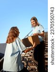 Small photo of Volunteers standing on stairs with boxes filled with humanitarian help, clothes, goods, food and meds for people and animals in need. Humanitarian aid, assistance and support, social programs concept