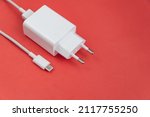 Charger and USB cable type C over red background