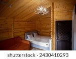 Small photo of The cabins interior is paneled with wood and furnished with a bed, sofa, and armoire. A bearskin rug adds a touch of warmth to the space.