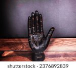 Small photo of A wooden hand, marked with palmistry notes