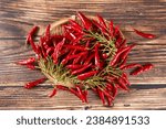 A bunch of ripe red hot chili peppers on wooden table.
