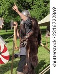 Small photo of Moscow, Russia - June 10, 2023: The annual festival "Times and Epochs". Viking berserker in chain mail with an axe in the skin of a bear. historical reconstruction.
