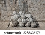 Stone balls in a gabion - ammunition for the old canons at at the ancient Fort Livrijenac, Dubrovnik, Croatia