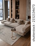 Small photo of living room, marble wall fireplace and stylish bookcase to the ceiling in a chic expensive interior of a luxurious country house with a modern design with wood and led light, gray furniturу