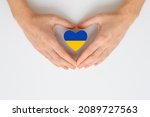 Small photo of The national flag of Ukraine in female hands. The concept of patriotism, respect and solidarity with the citizens of Ukraine.