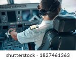 Top view of man in aviation uniform and earphones sitting at control and switching rudder while taking off