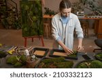Pretty woman making picture with green plants