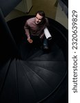 Small photo of Pleased draftsman climbing spiral staircase during tea break