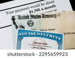 Small photo of A Corner of Social Security Administration annual statement showing benefits amount at full retirement age with check and ssn card. Concept of retirement planning.