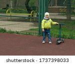 Small photo of The boy rides a blue scooter on a sports plod. Selective focus image.