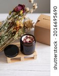 Small photo of Handmade organic soy candle on a neutral background. Square kraft box for candle packaging and shipping. Amber and opaque packaging. Vegan product without animal cruelty.