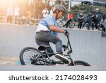 Small photo of Palembang, Indonesia 1 July 2022 - A young rider on a BMX bike starts the attraction. BMX freestyle in a skate park.