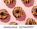Chocolate Donut with peanut butter frosting on a pick background. Chocolate Doughnuts dipped in peanut butter on pink backdrop. 