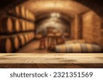 Empty wooden table. Blurred wine cellar in the background. Winery and beverage concept