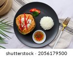 Small photo of Steamed fish curry in banana leaf cups served with white rice and spicy fish sauce - Famous Thai food called Hor Mok or fish Amok at top view on marble table