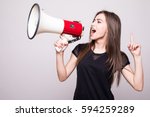 Pretty girl shouting into megaphone on copy space