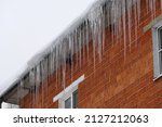 Large icicles on the roof of the house. High quality photo