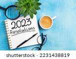New year resolutions 2023 on desk. 2023 resolutions list with notebook, coffee cup on table. Goals, resolutions, plan, action, checklist concept. New Year 2023 background, copy space