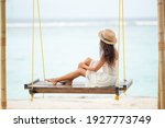 Girl sitting on a swing looking at the ocean