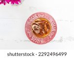 Glass of iced caramel macchiato on white wooden table background, top view.