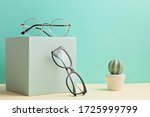 Stylish eyeglasses over pastel  background. Optical store, glasses selection, eye test, vision examination at optician, fashion accessories concept. Front view 