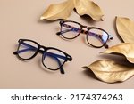 Stylish eyeglasses over pastel  background. Optical store, glasses selection, eye test, vision examination at optician, fashion accessories concept. Top view, flat lay