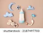 Small photo of Flat lay with baby sleep accessories with milk bottles, pacifier and toys. Newborn sleeping rules concept