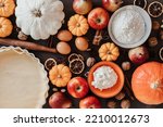 Fall pie baking ingredients with pumpkins, apples, pears, nuts, seasonal spices and tools. Cooking pumpkin or apple pie. Thanksgiving and autumn holidays celebration concept