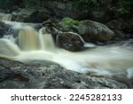 Silky flow of powerful rapids and falls in a swollen Sugar River in summertime in Newport, New Hampshire.