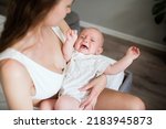 Small photo of Newborn crying boy. the child is tired and hungry in the arms of the mother. children are crying. infant cry.