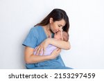 Small photo of Beautiful young mother with a newborn daughter in a diaper on a white background. Motherhood. Tenderness. Space for text. High quality photo