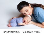 Small photo of Beautiful young mother with a newborn daughter in a diaper on a white background. Motherhood. Tenderness. Space for text.