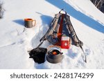 Small photo of A first aid kit complements a tourist's equipment on a winter hike, camping in nature in the forest, dishes in the snow, a backpack for things. High quality photo