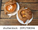 Hungarian goulash in bread bowl on wooden table. Street food in Budapest,  Hungary. Top view.