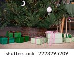 Close up of gift boxes under the christmas tree wihh wicker base. Christmas, New Year concept. Selective focus.