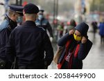 Small photo of Bucharest, Romania - October 13, 2021: Romanian policemen and jandarmi ask passers-by to wear their face masks during the Covid-19 pandemics.