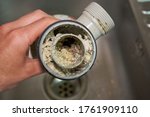 Small photo of clogged sink pipe,in the hands of a clogged dirty sewer pipe from leftover food