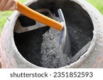 Small photo of Construction site. Adding lime, sand and stones to rotating cement mixer. Builder working with shovel during concrete solution mortar preparation. Bricklayer job machine equipment. Cement slurry