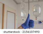 Small photo of hygiene on the treatment. A bottle of medicine and latex gloves of medical nurse staff in the hospital. Covid, cancer, surgery protection. Drugs infusion or transfusion.