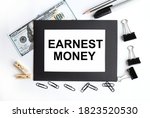 Small photo of earnest money. text on white paper on black envelope