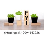 Small photo of FYI. text on wood blocks on light background
