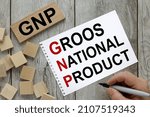 Small photo of GNP Gross Domestic Product text on a sheet of paper and on sticky tape. on a wooden table