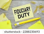 Small photo of fiduciary duty text on yellow note paper and work desk. Finance concept.