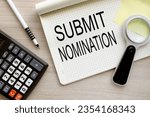 Small photo of SUBMIT NOMINATION magnifying glass on the page. open notebook with text. wooden background.