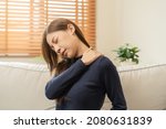 Small photo of Body muscles stiff problem, asian young attractive woman, girl pain with back pain ache from work, holding massaging rubbing shoulder hurt or sore, painful sitting on sofa at home. Healthcare people.