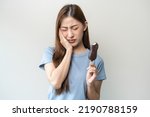 Face expression suffering from sensitive teeth and cold, asian young woman, girl feeling hurt, pain eating ice cream, lolly. Toothache molar tooth at home, dental problem isolated on white background.