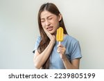 Small photo of Face expression suffering from sensitive teeth and cold, asian young woman, girl feeling hurt, pain eating ice cream, lolly. Toothache molar tooth at home, dental problem isolated on white background.